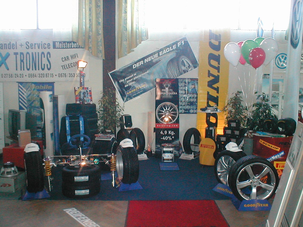 Zweite Ansicht des Reifenbert-Messestands in Pöggstall 2002 mit Reifen, Felgen und Fahrwerksmodell